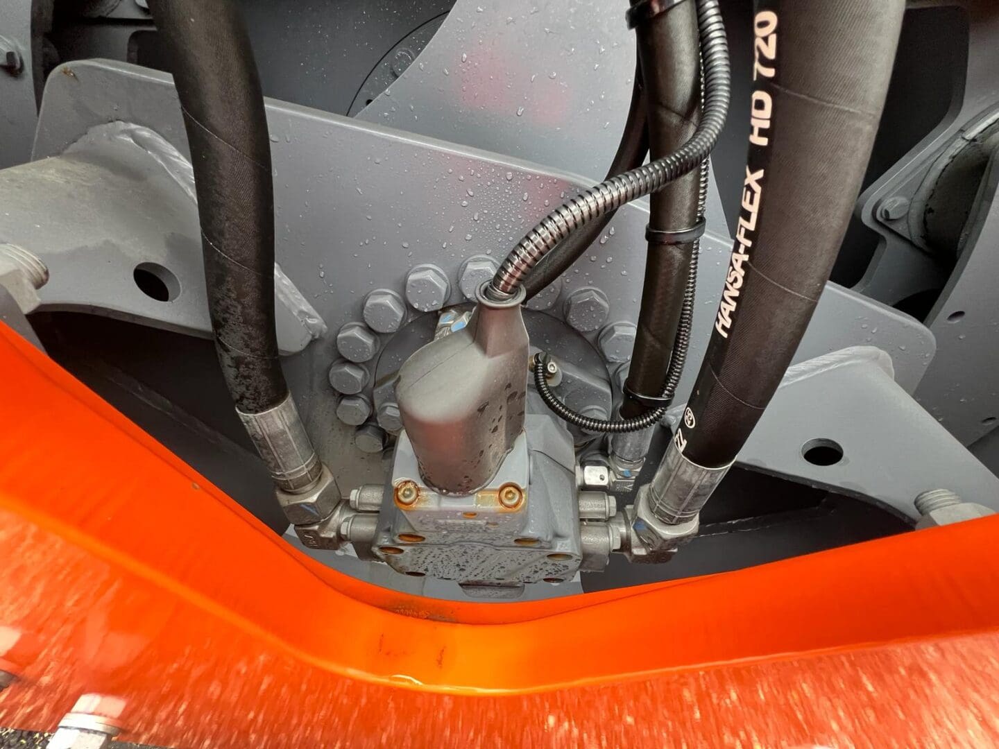 Hydraulic hoses and fittings on orange machinery