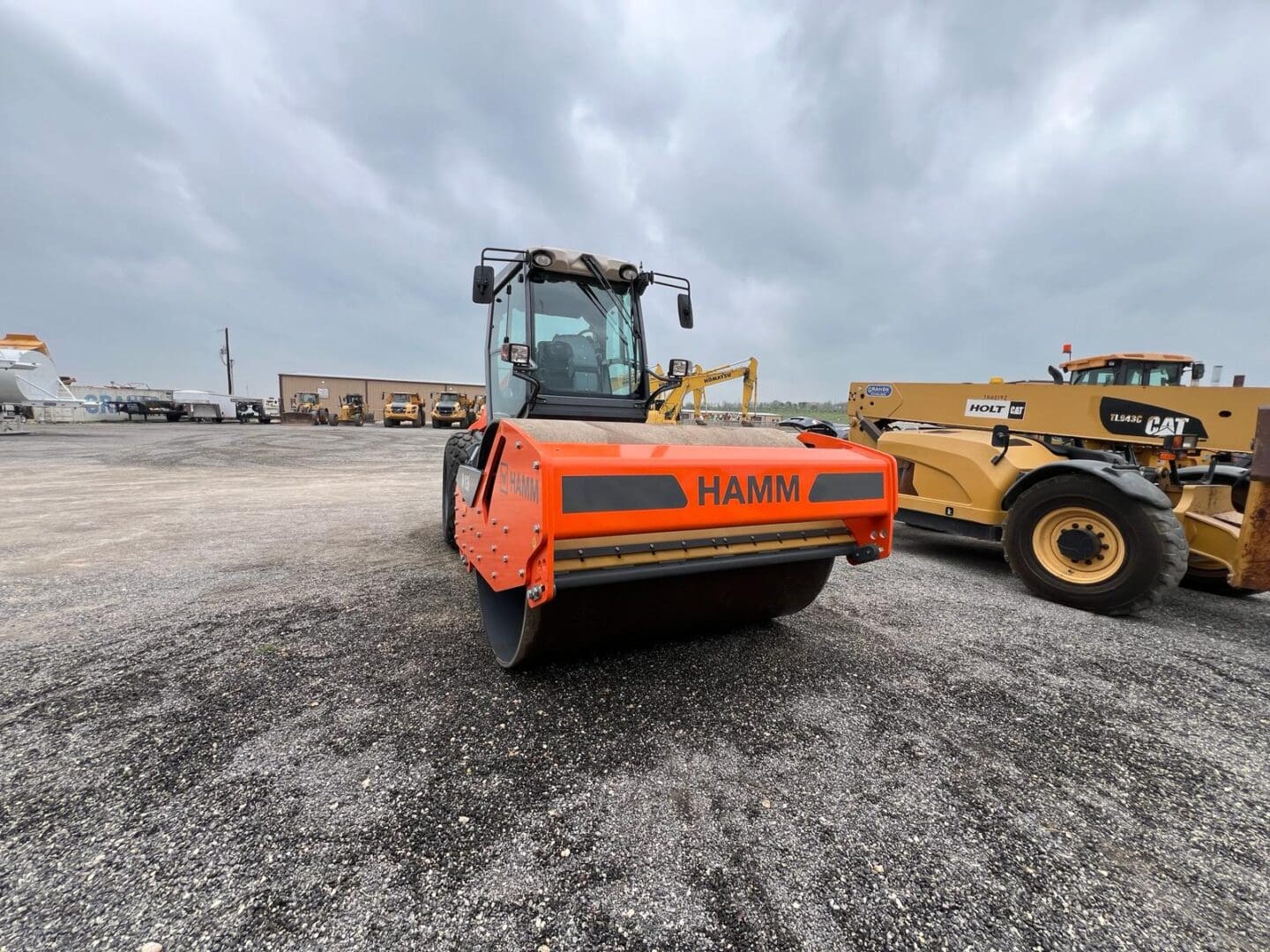 Orange HAMM road roller on gravel lot