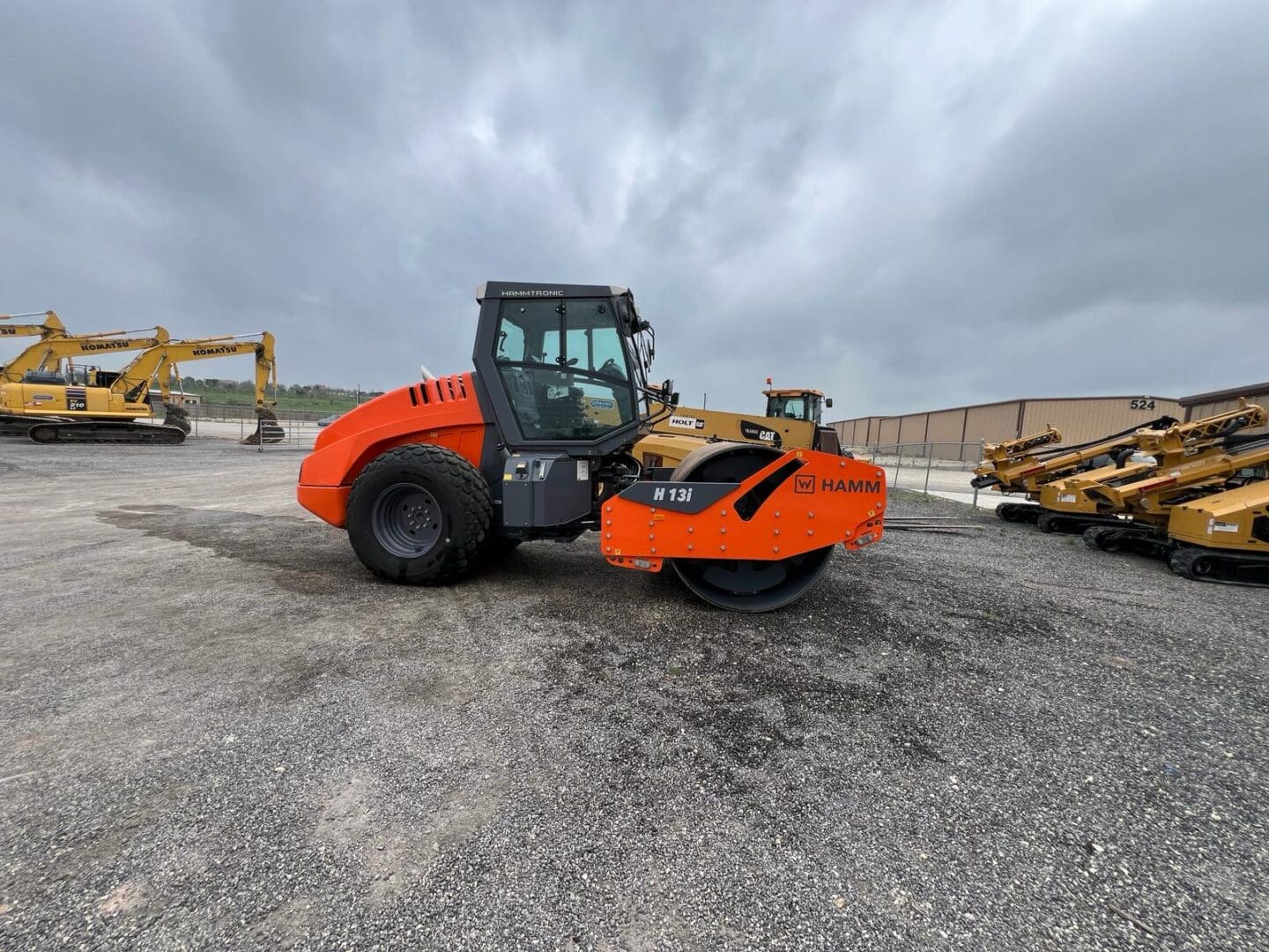 Orange road roller compactor in equipment yard