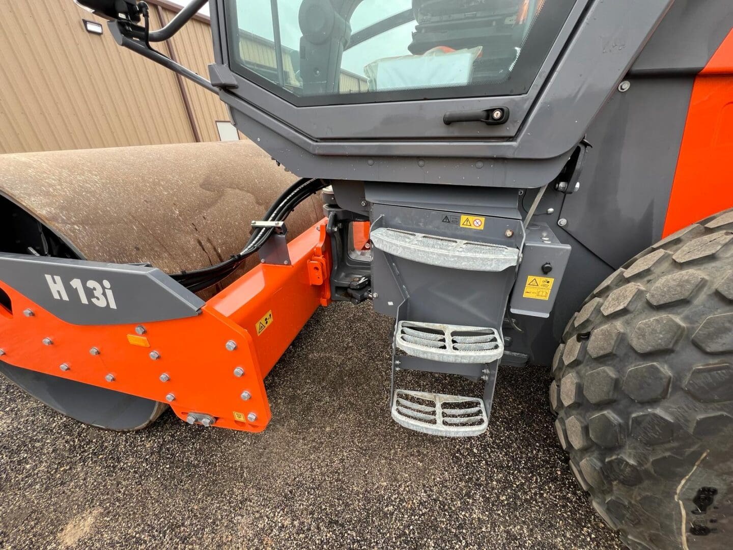 Orange road roller compactor with metal drum