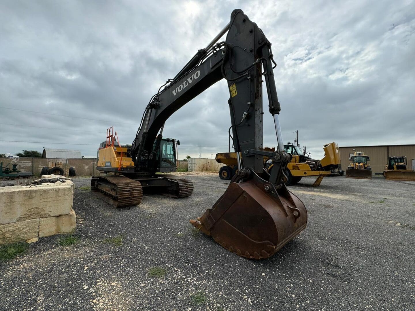 Volvo excavator with bucket on gravel lot
