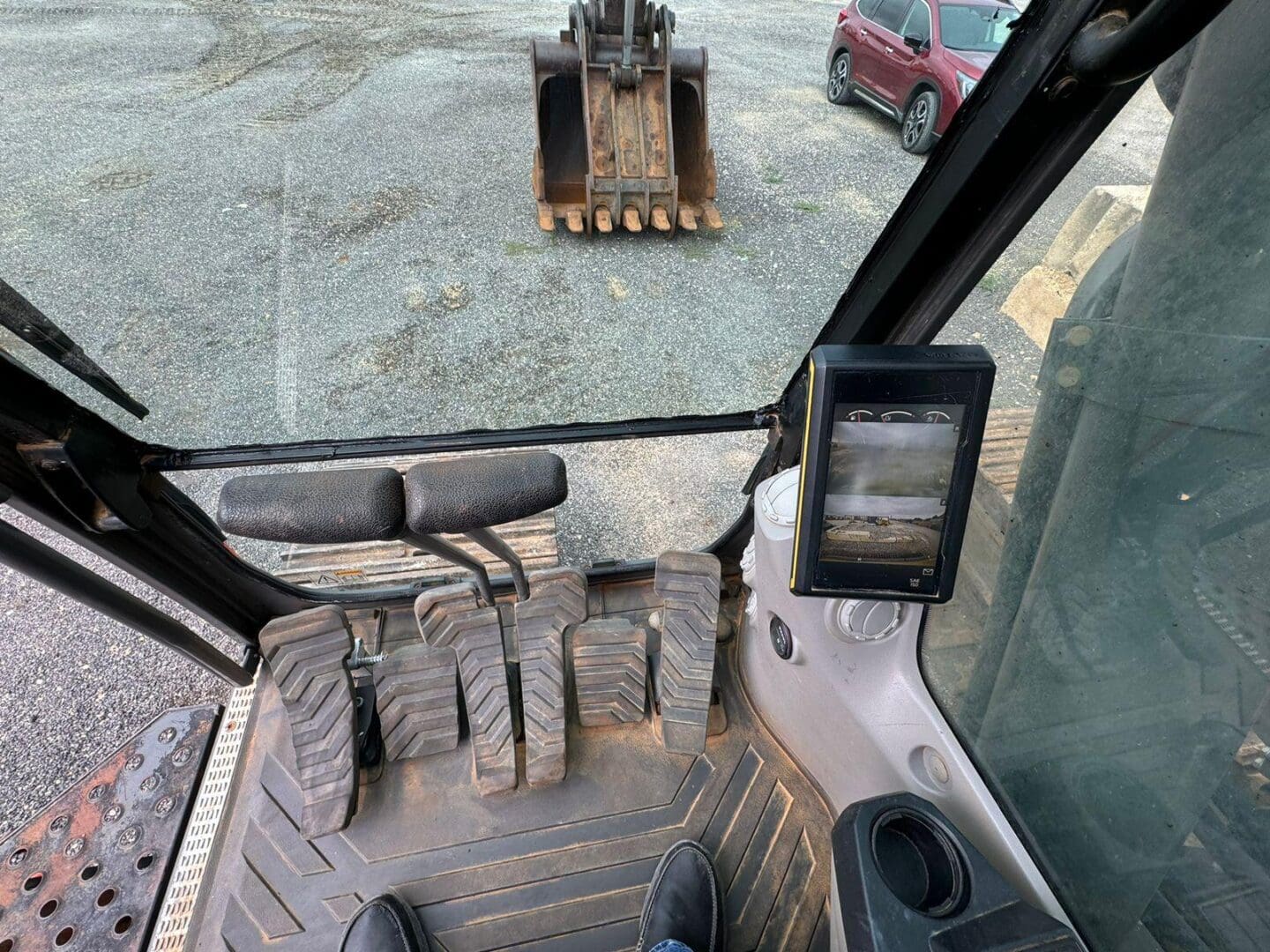 Excavator cabin interior with pedals and bucket