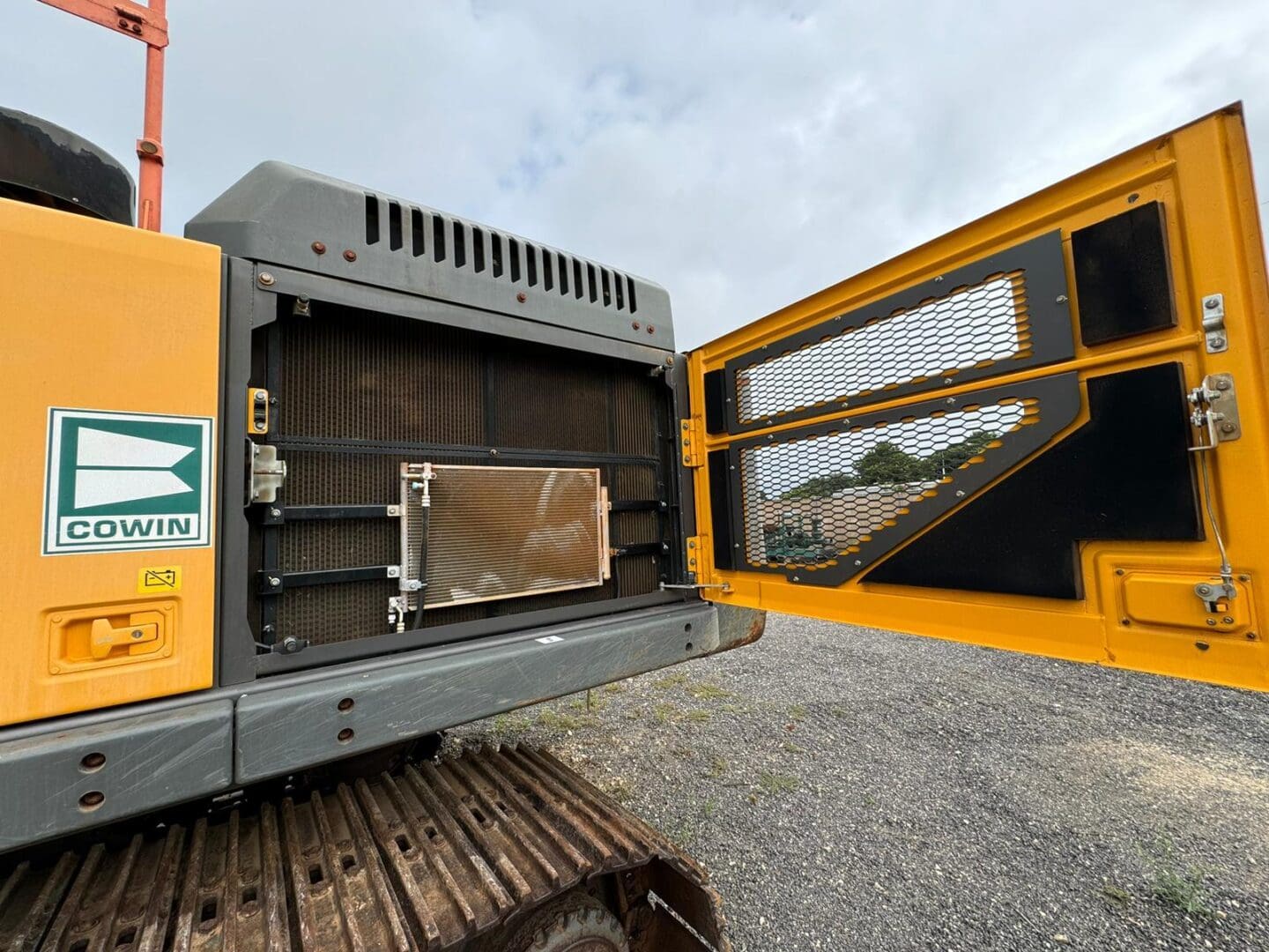 Yellow excavator with open engine compartment