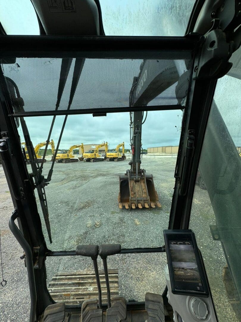 Inside excavator cab looking at bucket