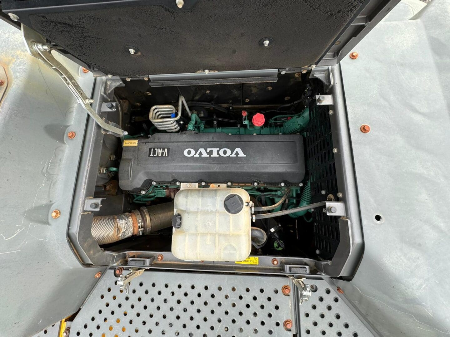 Open compartment showing Volvo engine and reservoir
