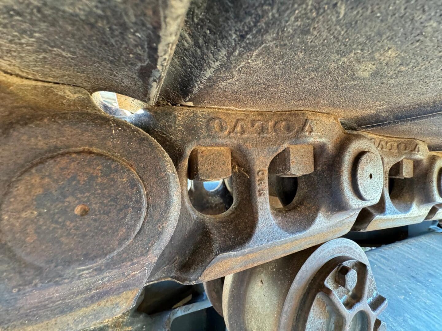 Rusty excavator track and sprocket close-up