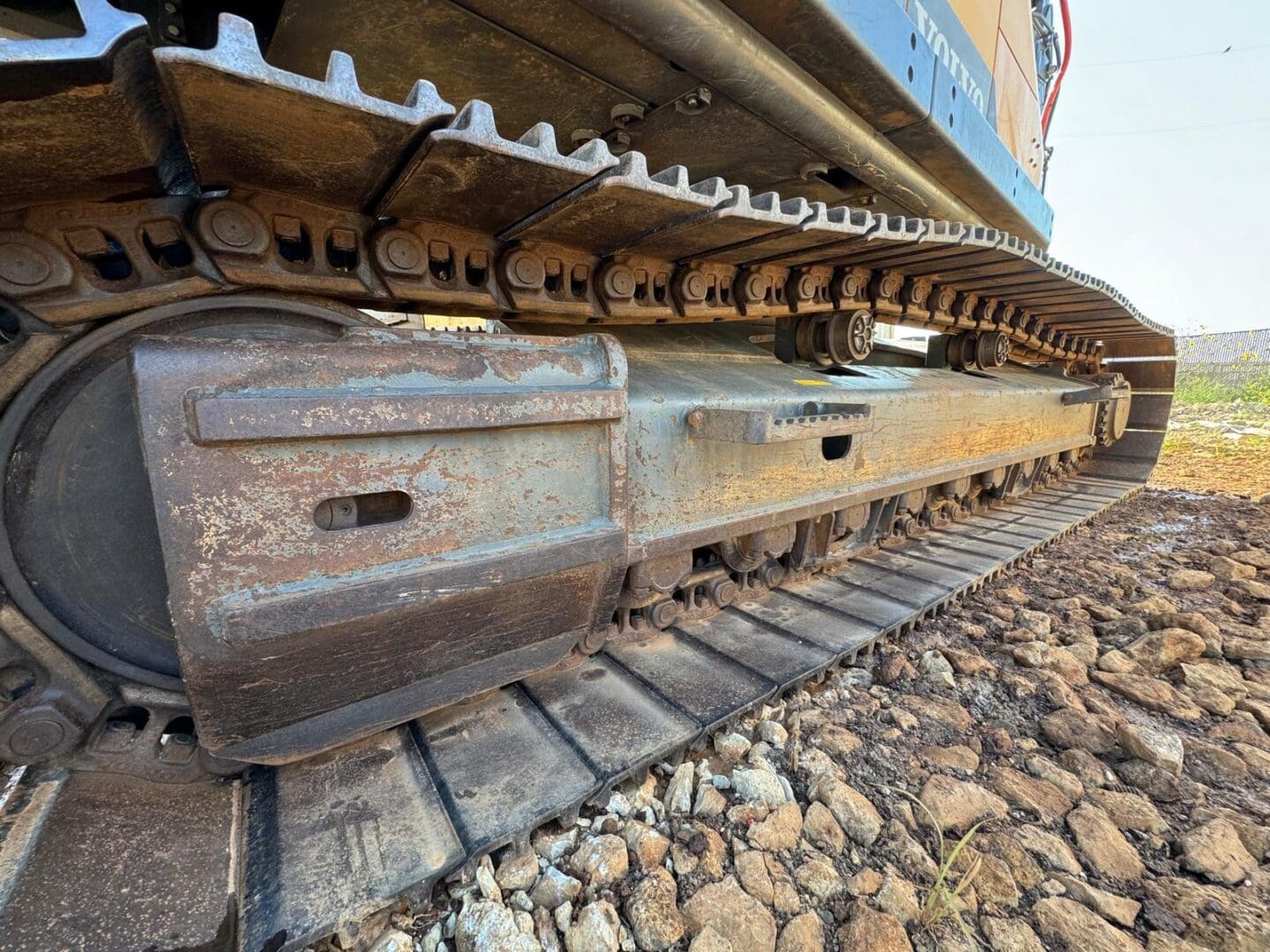 rusty excavator track on rocky ground