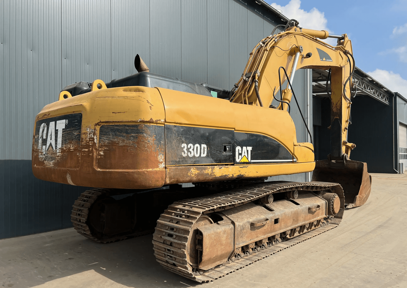 Yellow Caterpillar 330D excavator by warehouse
