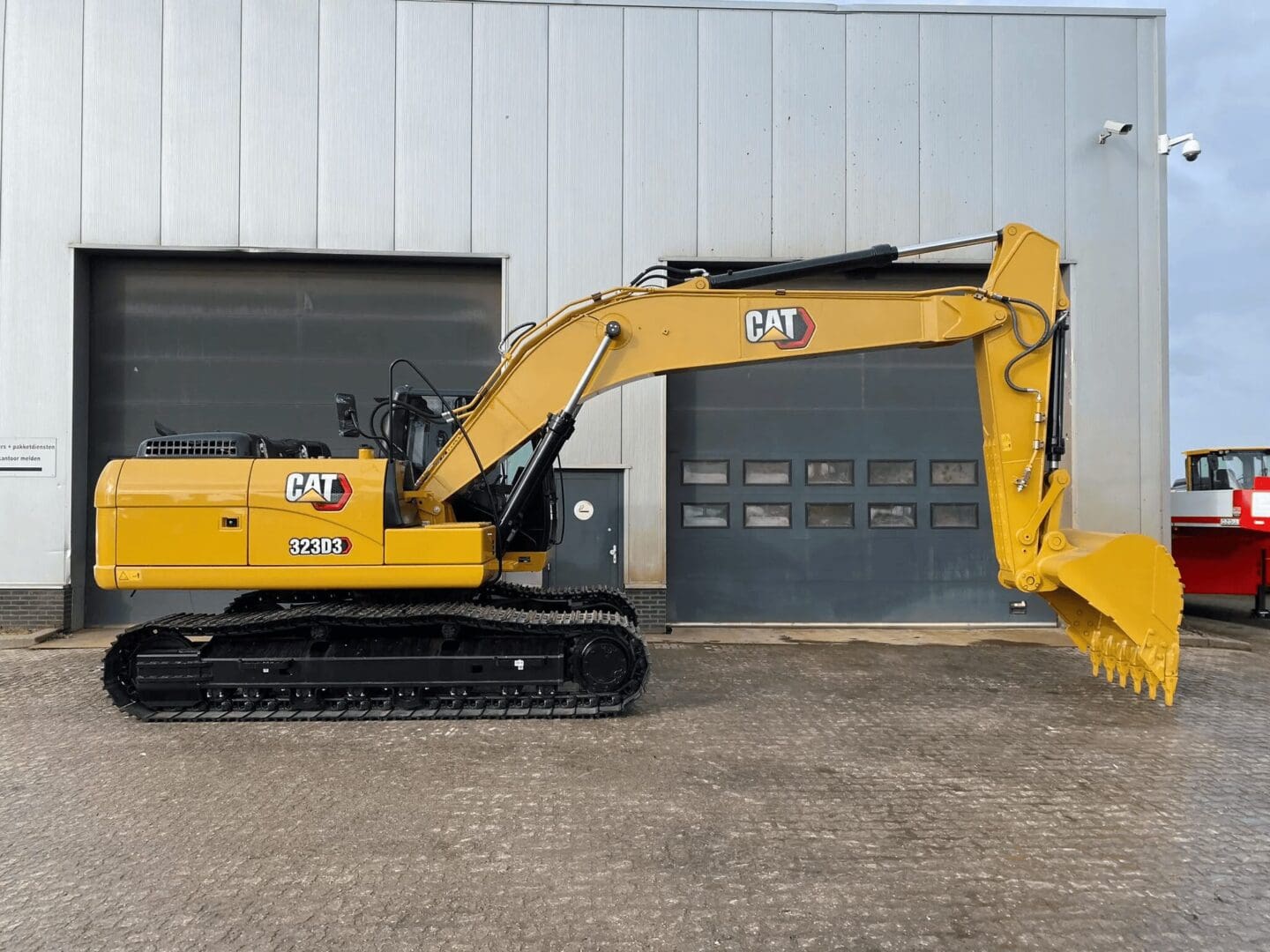 Yellow CAT excavator parked by industrial garage