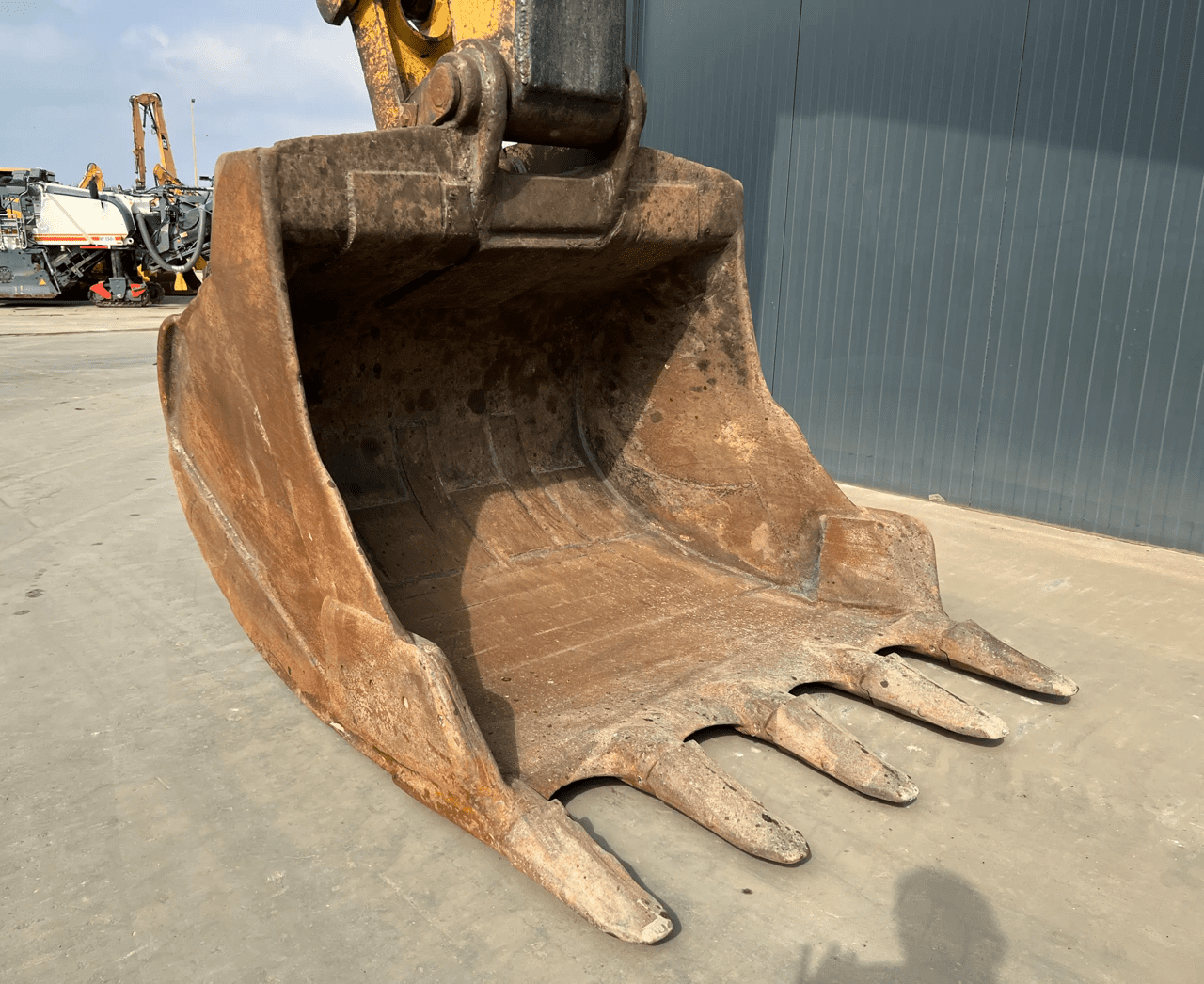 Rusty excavator bucket with worn teeth