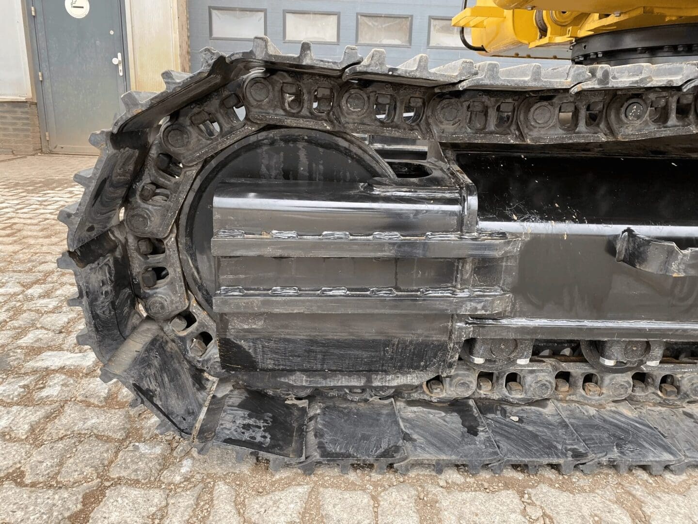 Close-up of excavator rubber track and rollers