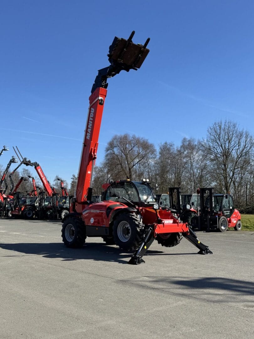 Red telehandler with extended boom and stabilizers