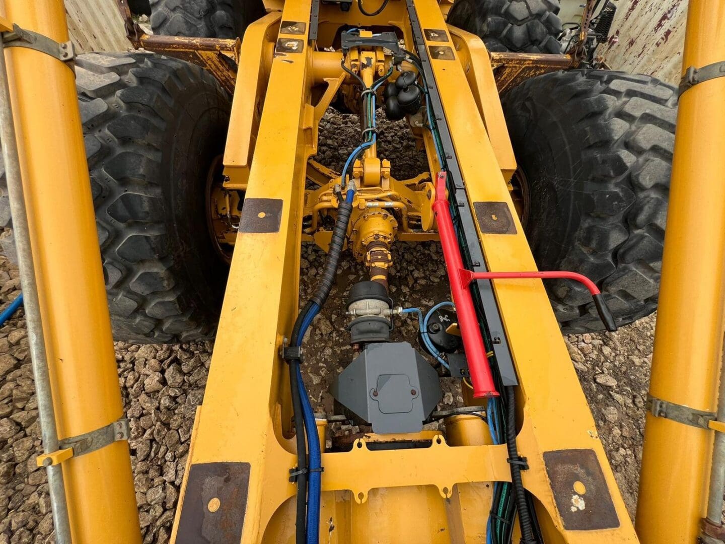 Underframe of yellow construction vehicle with hydraulics