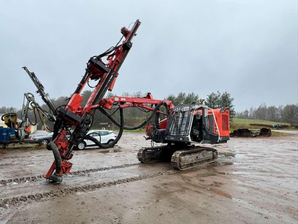 red tracked drilling rig on muddy site