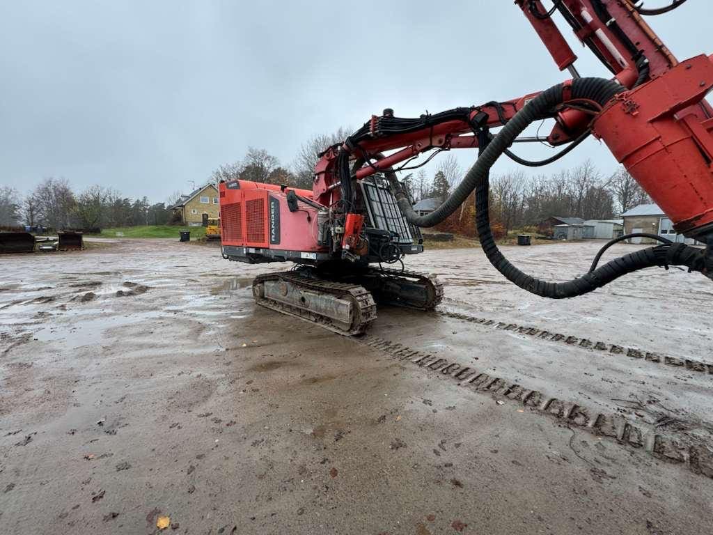 Red tracked excavator on muddy construction site