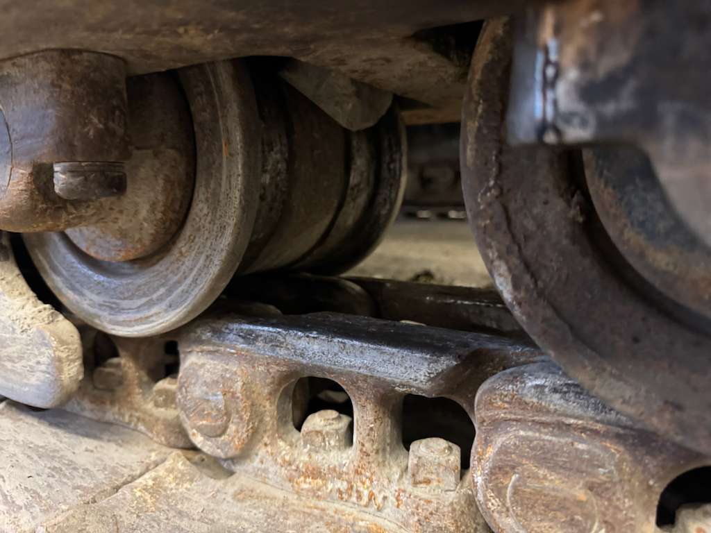 Close-up of rusty track rollers and links