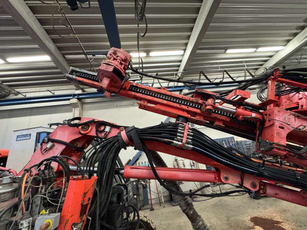 Red industrial hydraulic robotic arm in workshop