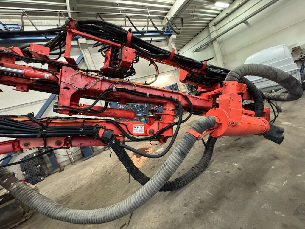 Red hydraulic industrial arm with flexible hoses