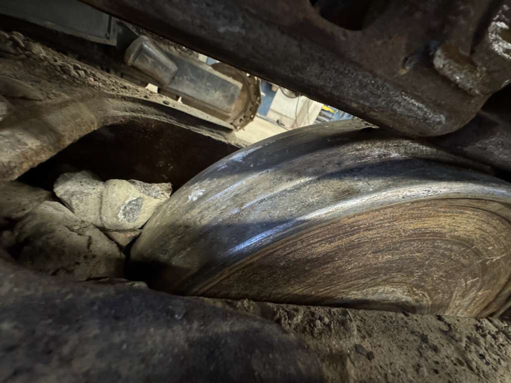 Worn excavator track roller close-up