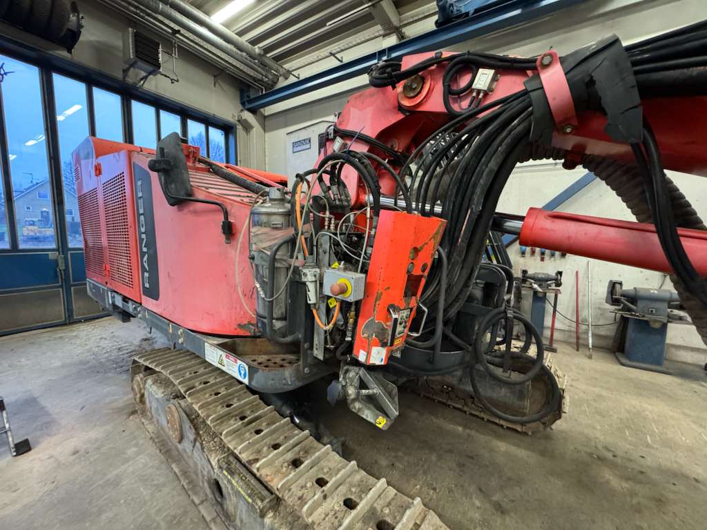 Red tracked hydraulic drill inside workshop