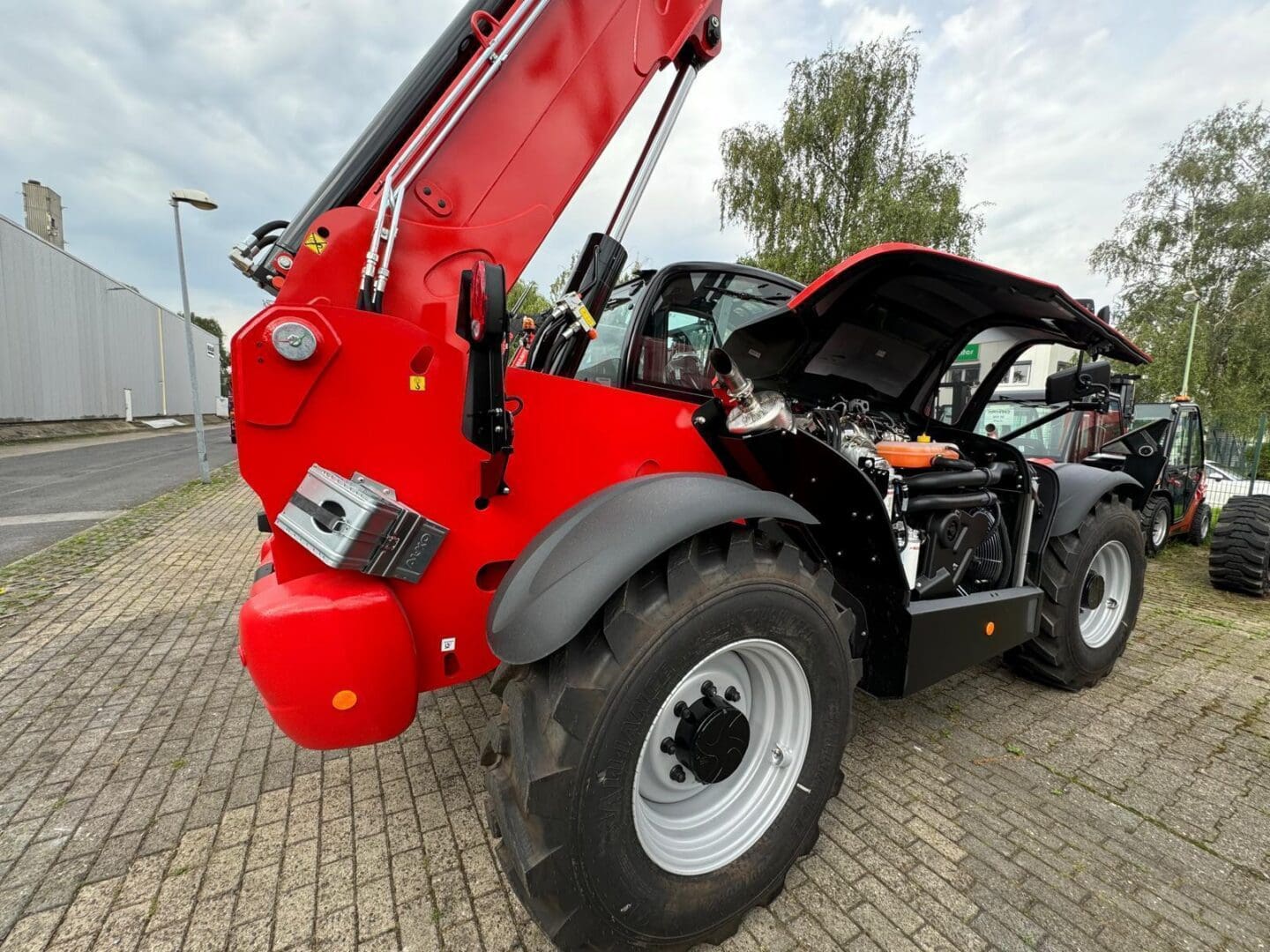 Red telescopic handler with open engine compartment