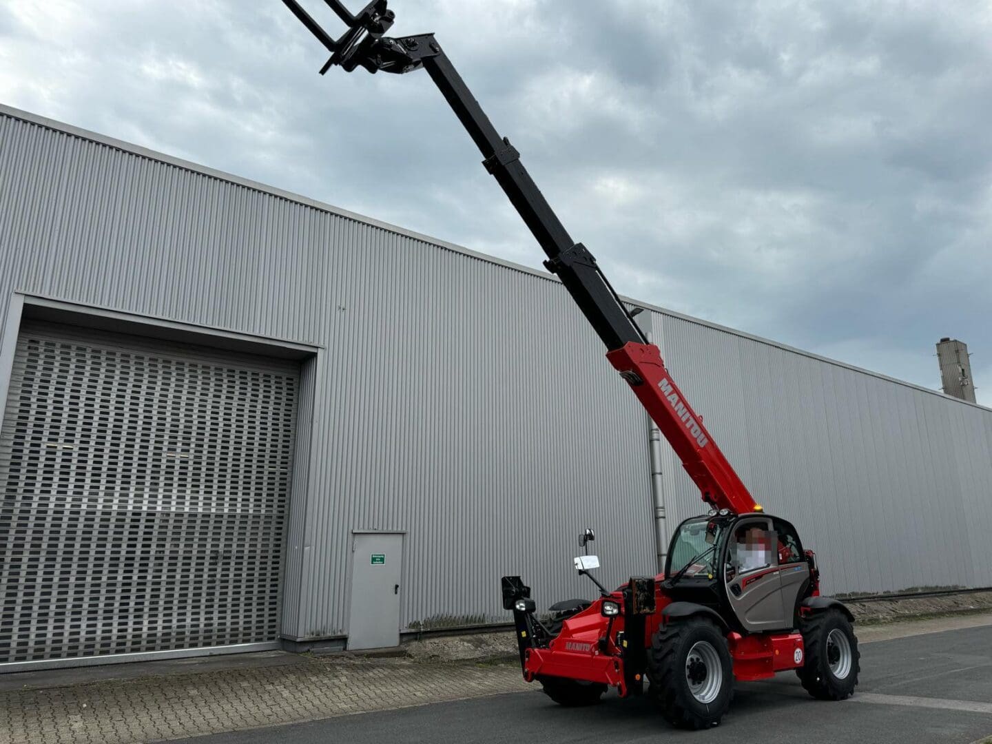 Red telescopic handler with extended forks