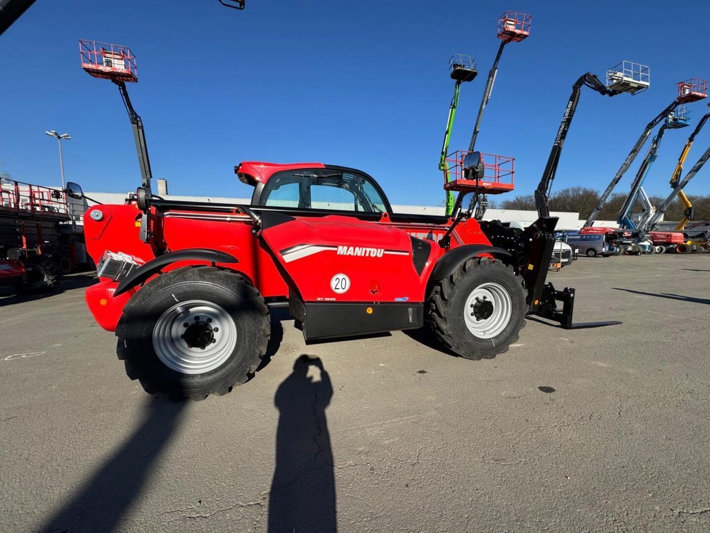 Red Manitou telescopic handler with aerial lifts