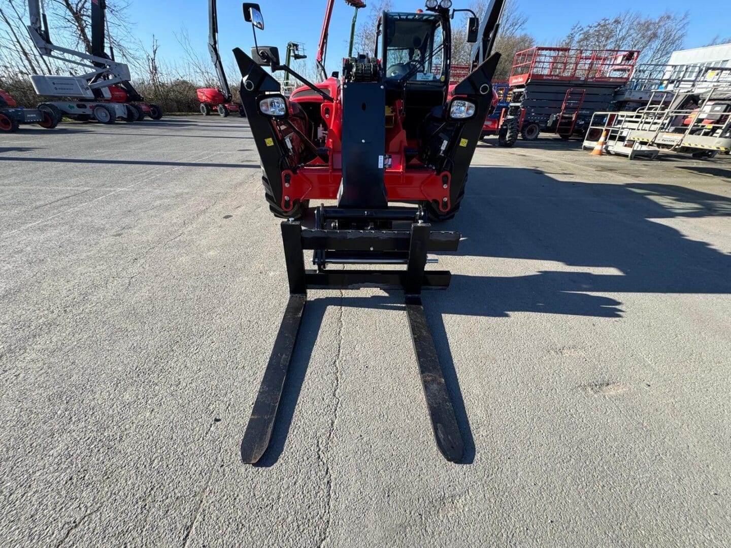 Red telehandler with extended pallet forks