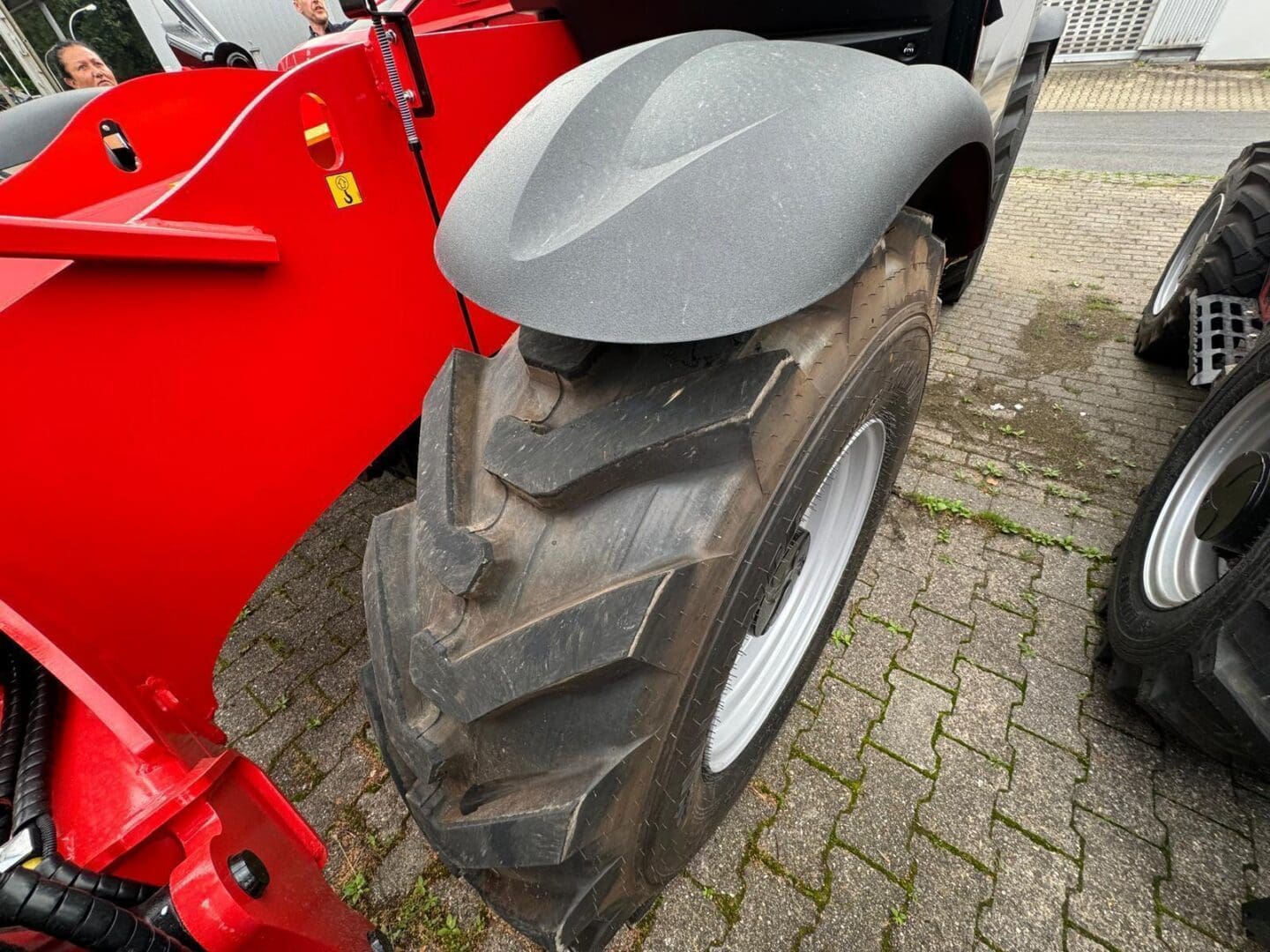 Large tractor tire with red vehicle fender