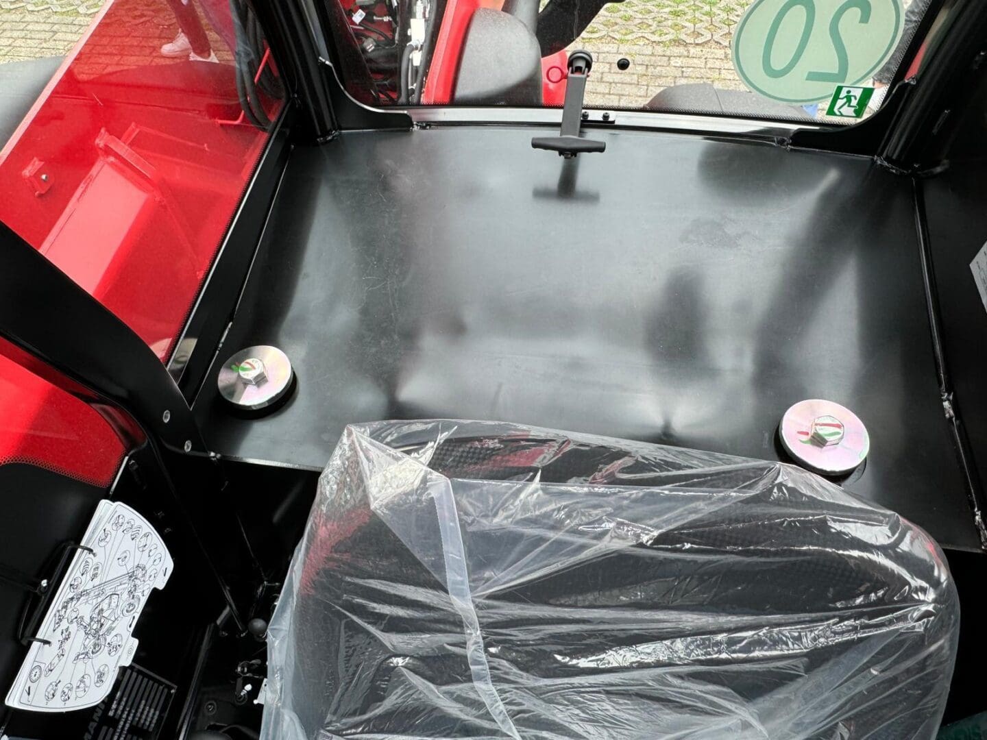 Plastic-covered driver seat in small red cabin