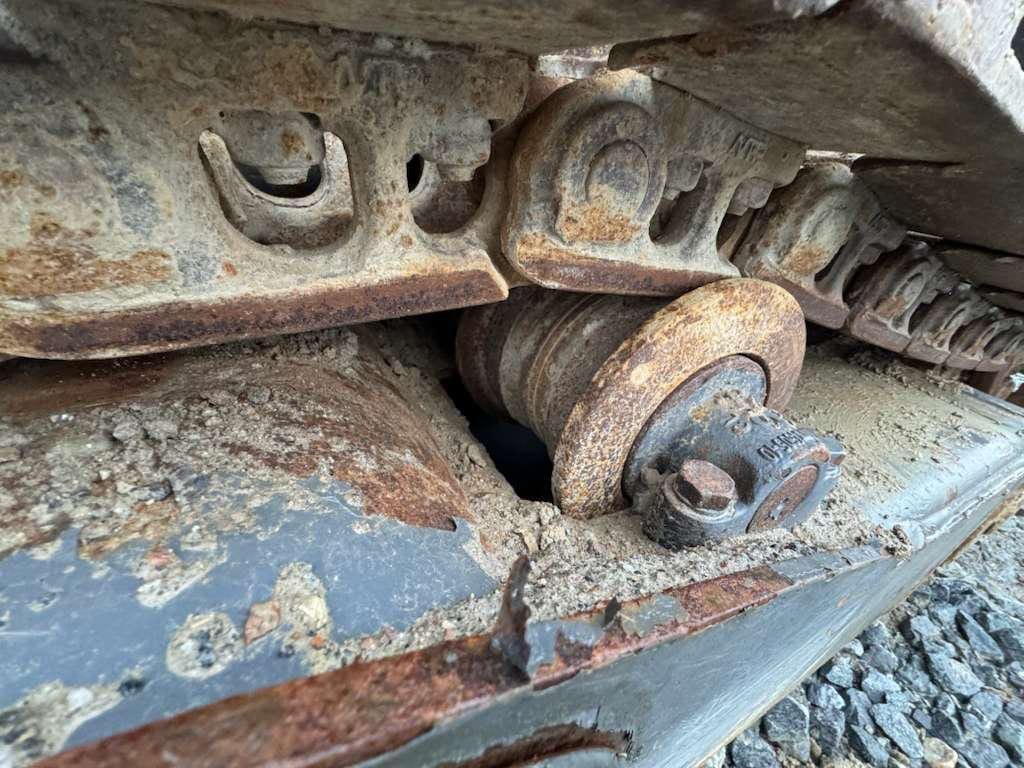 Rusty excavator track roller and metal links