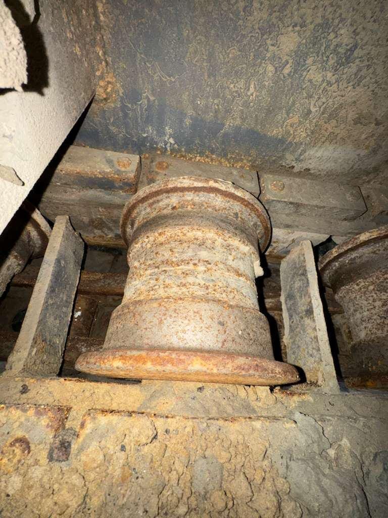 Rusty industrial roller wheel between metal supports