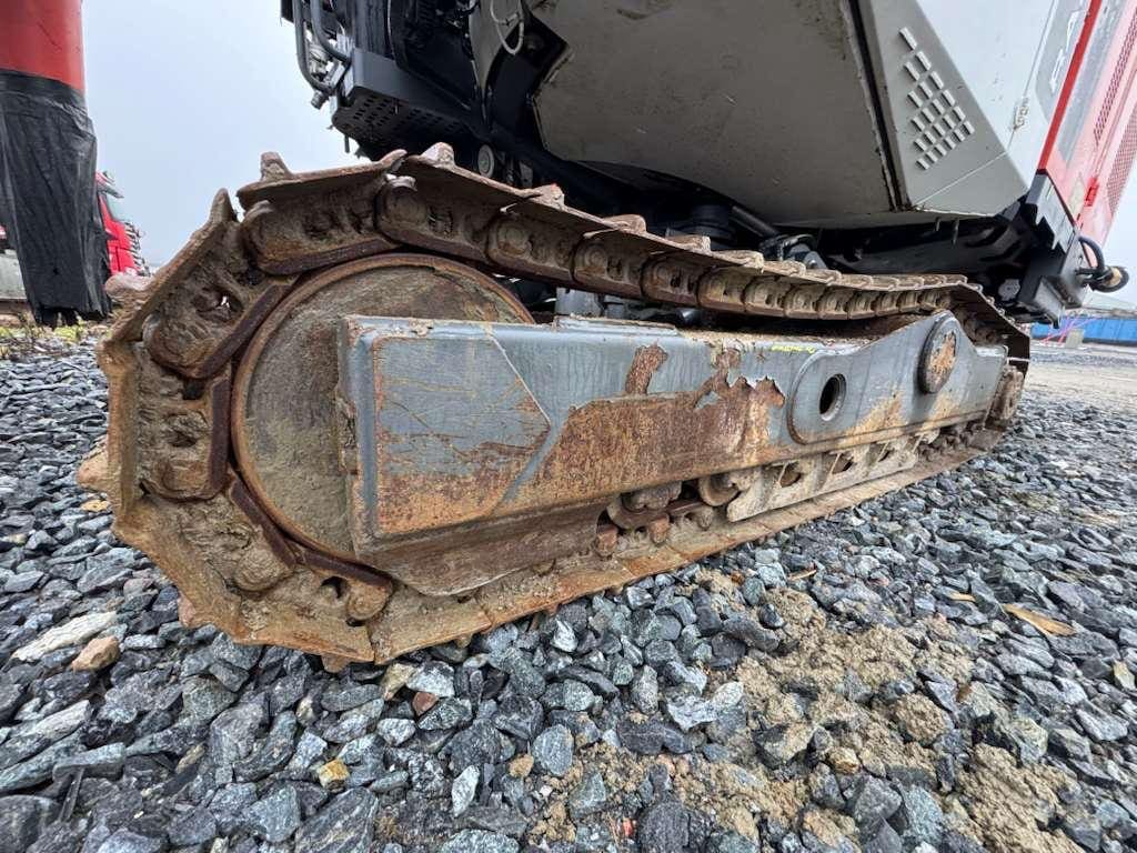 Rusty excavator track on gravel surface