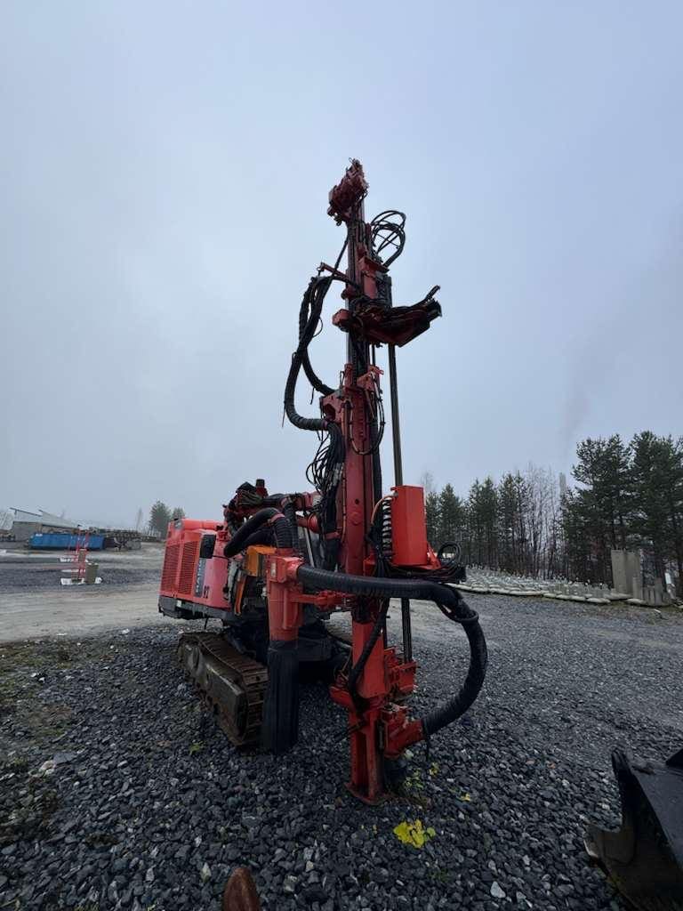 Red tracked drilling rig at gravel construction site