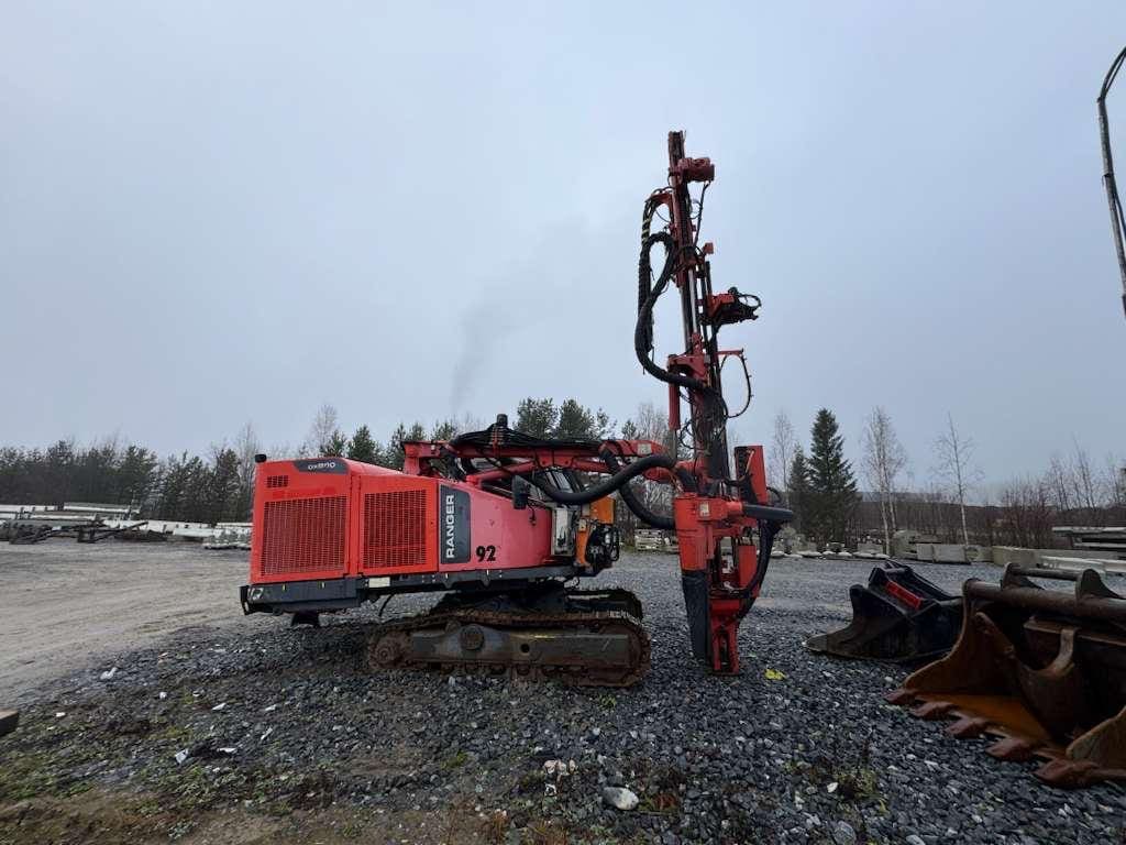 Red tracked drilling rig on gravel lot