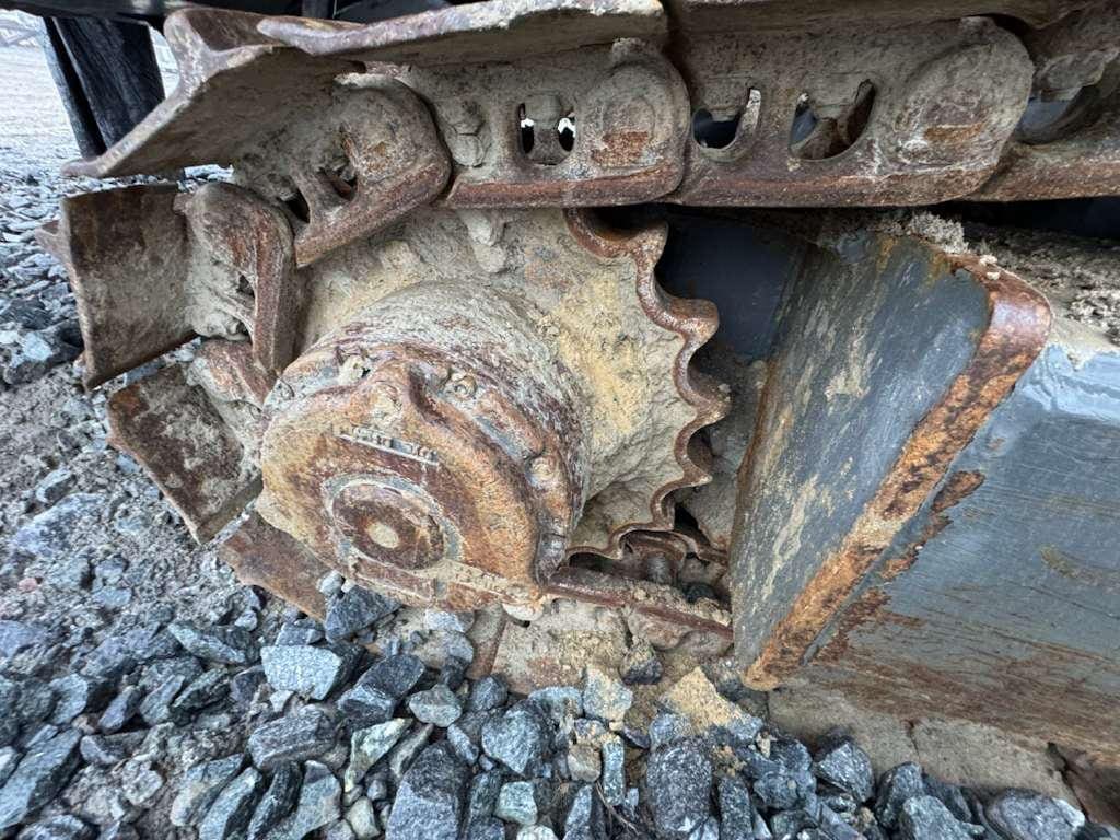 Rusty excavator track sprocket on gravel