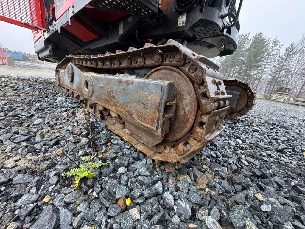 Rusty excavator crawler track on gravel