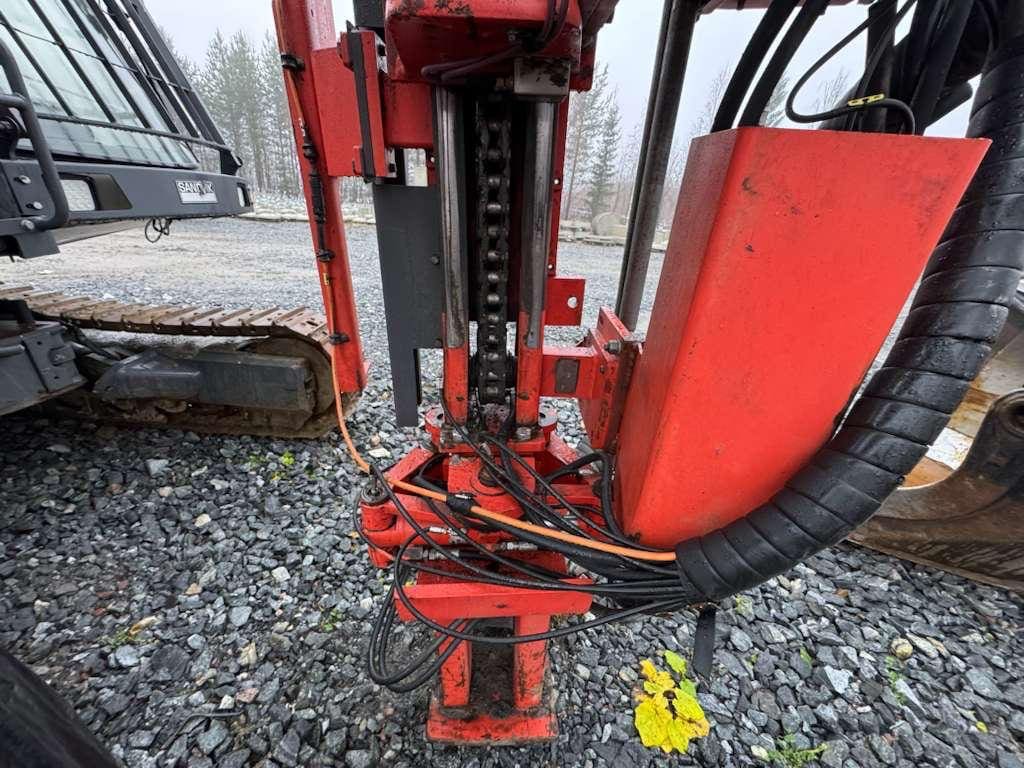 Red hydraulic excavator attachment with hoses