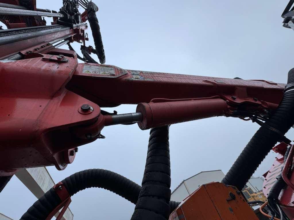 Red hydraulic construction arm with hoses