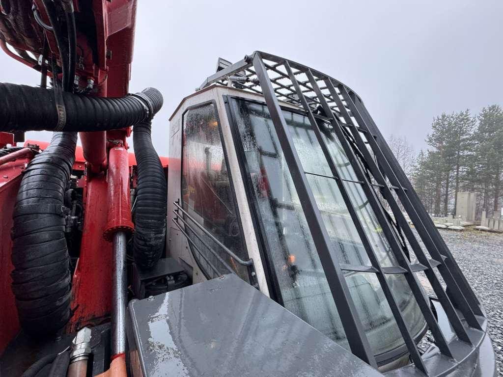 Heavy machinery cabin with metal protective grille