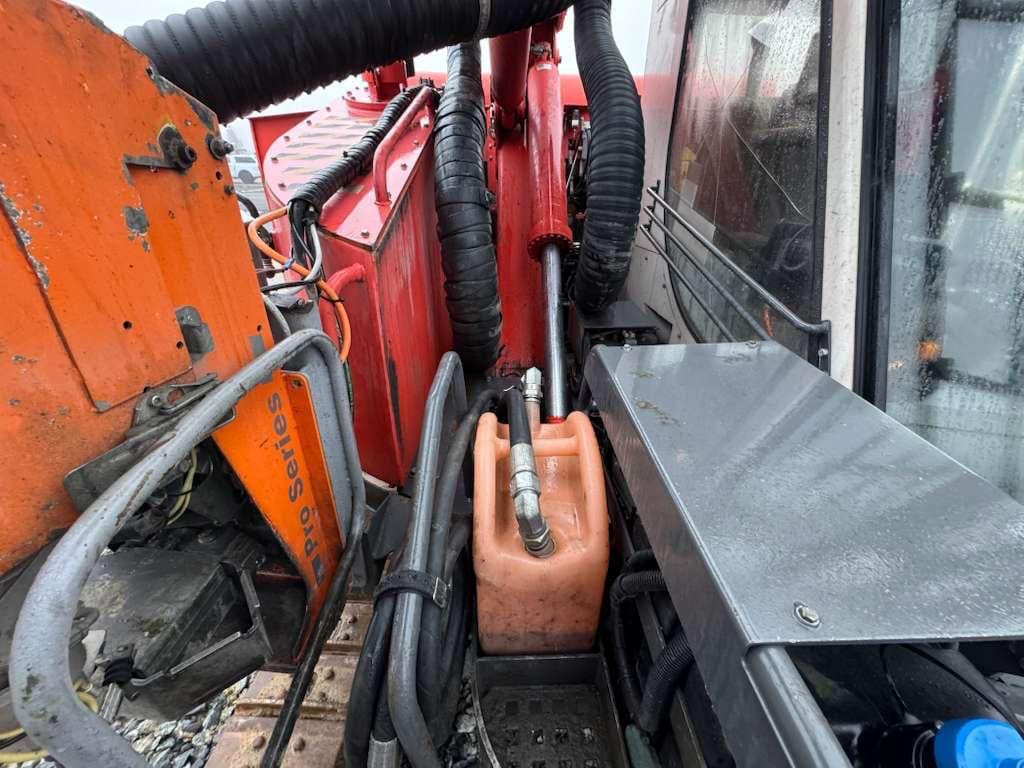 Close-up of hydraulic hoses and orange reservoir