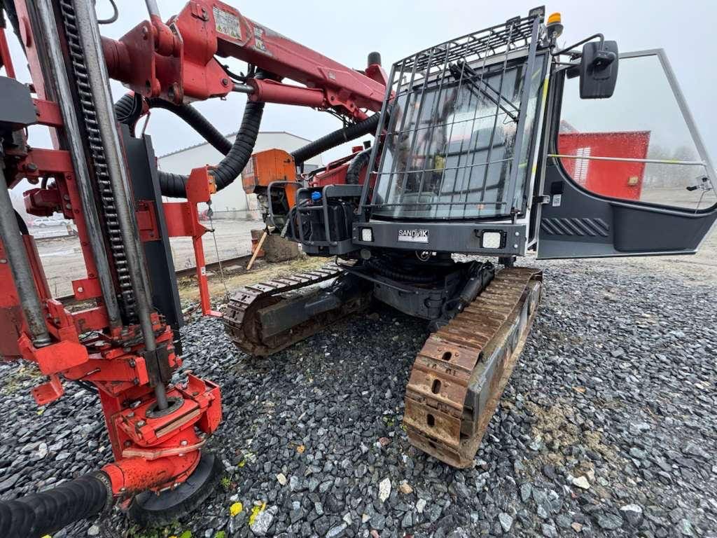 Tracked drilling rig with red drill arm