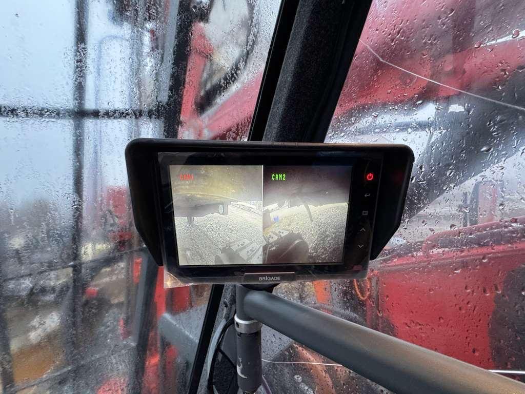Monitor inside wet tractor cabin showing rear camera