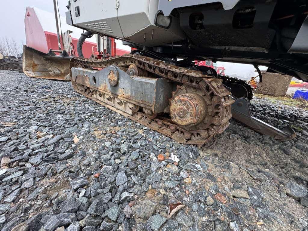 Rusty excavator track on gravel surface